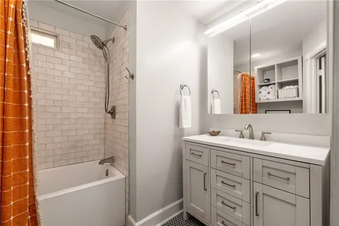 a bathroom with a double vanity sink a mirror a bathtub and shower