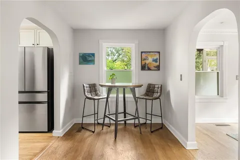 a view of a kitchen with refrigerator and wooden floor