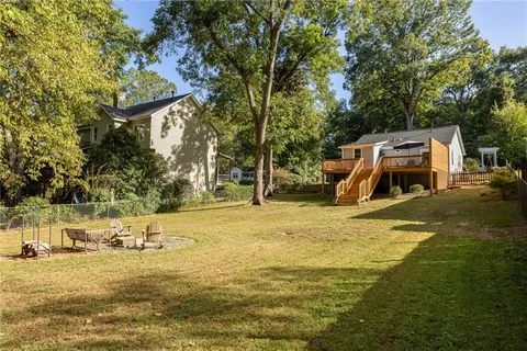 a view of a swimming pool with lawn chairs and plants