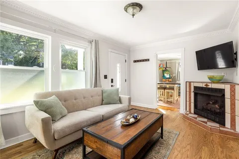 a living room with furniture a flat screen tv and a fireplace