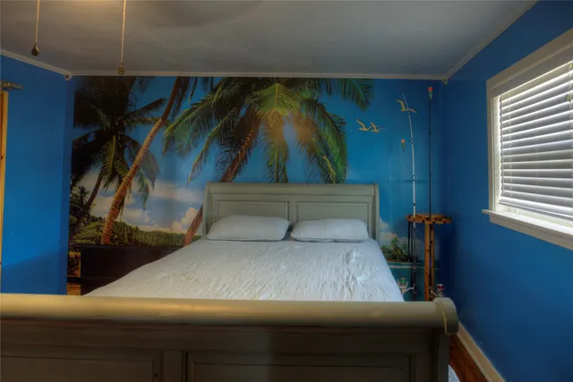 a bed sitting in a bedroom next to a window