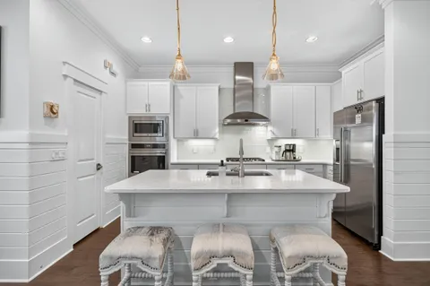 a kitchen with cabinets stainless steel appliances and wooden floor