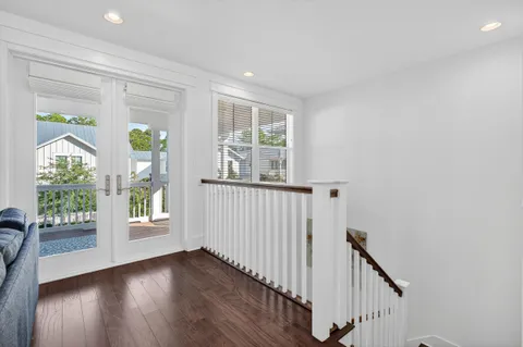a living room with furniture a computer on the desk and a rug