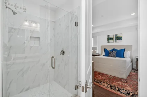 a bathroom with a granite countertop sink a toilet and shower