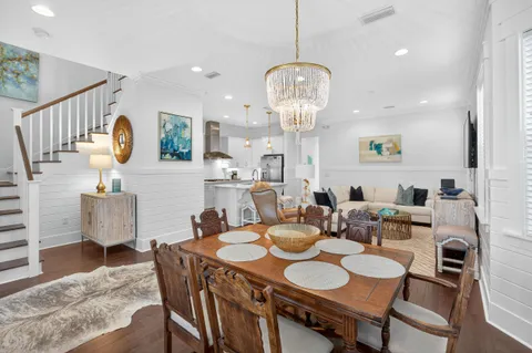 a dining room with furniture a chandelier and wooden floor