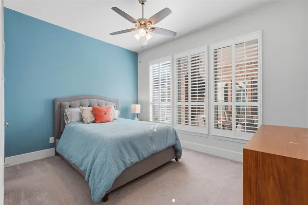 a bedroom with a bed lamp and a large window