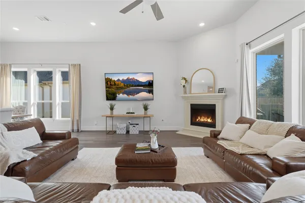 a living room with furniture a fireplace and wooden floor