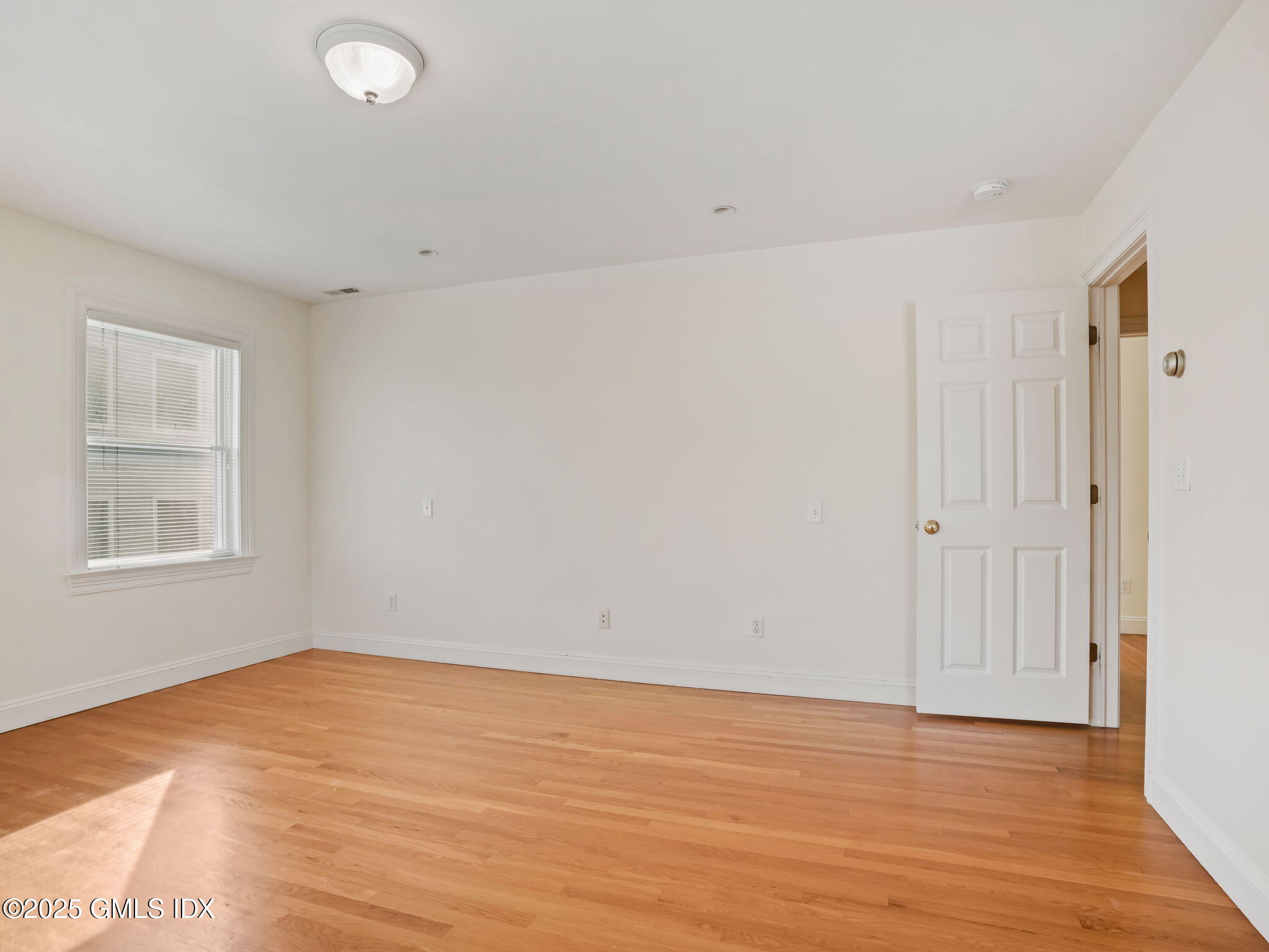 6 Rippowam Road, Unit A Cos Cob, CT 06807 - Photo 17 of 32 a view of an empty room with wooden floor and a window
