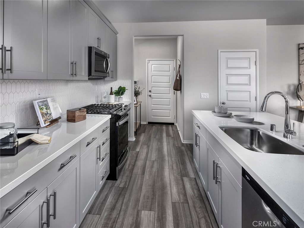 2052 Tangelo Lane Redlands, CA 92374 - Photo 2 of 15 a kitchen with a sink cabinets and stainless steel appliances