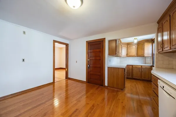 a view of an empty room with a window and wooden floor