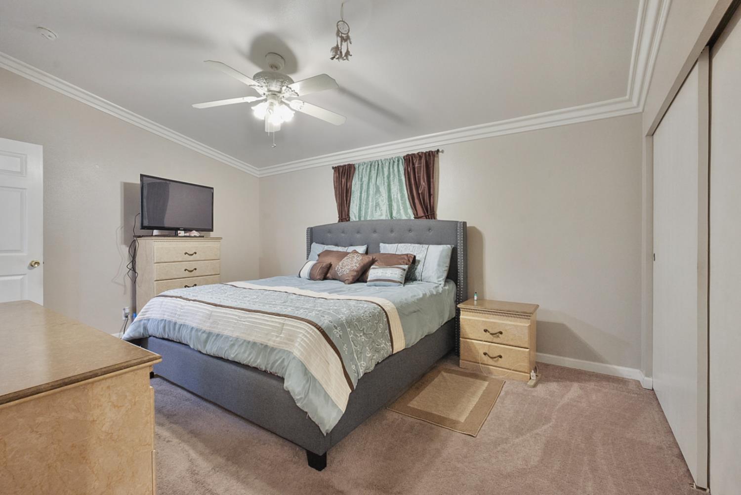 2841 Fowler Road, Unit 33 Ceres, CA 95307 - Photo 17 of 29 a bedroom with a large bed and a ceiling fan