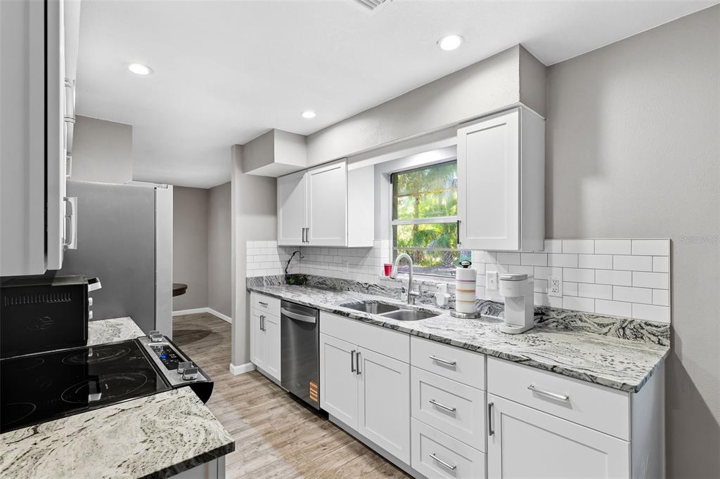 12210 State Street Tampa, FL 33635 - Photo 14 of 41 a kitchen with a sink stove and cabinets