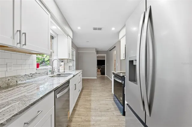 a kitchen with a sink stove and refrigerator