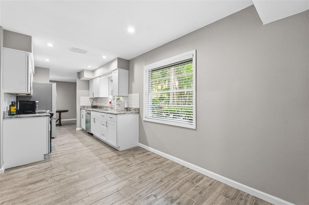 12210 State Street Tampa, FL 33635 - Photo 17 of 41 a kitchen with granite countertop white cabinets and white appliances
