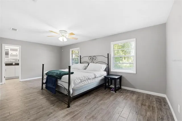 a bedroom with a bed and wooden floor