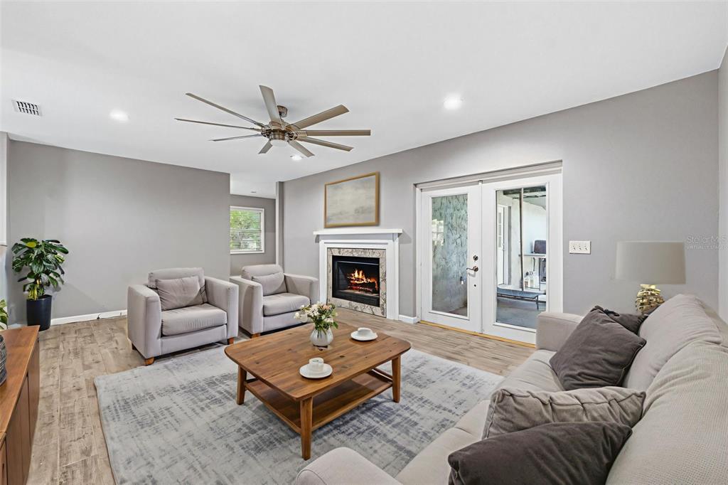 12210 State Street Tampa, FL 33635 - Photo 9 of 41 a living room with furniture a fireplace and a chandelier