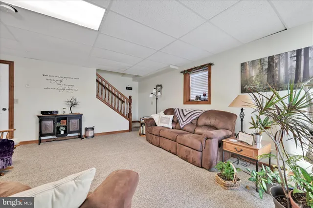 a spacious bedroom with a large bed a chandelier and dresser