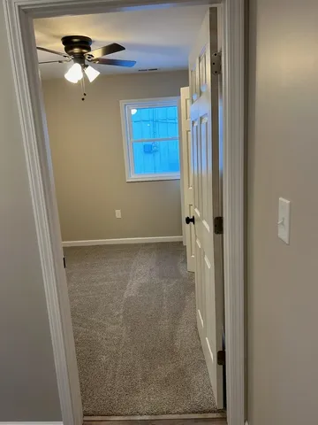 a view of a livingroom with a ceiling fan and window