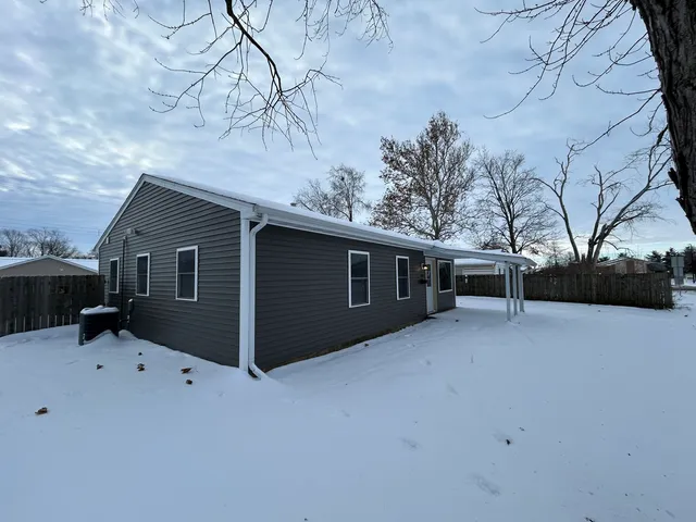 a front view of house with yard and trees in the background