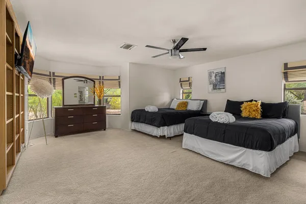 a spacious bedroom with a bed and ceiling fan