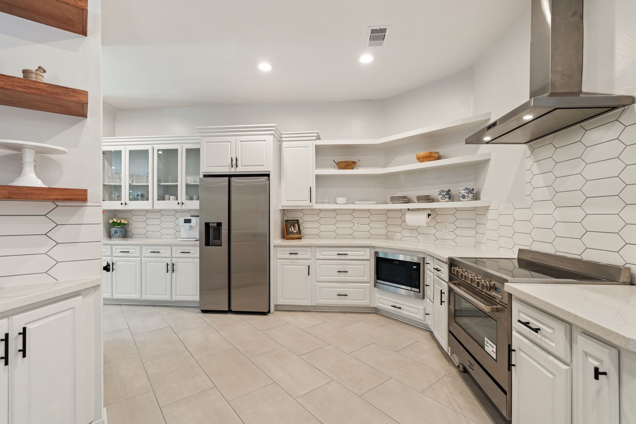 201 Vanderpool Lane, Unit 137 Houston, TX 77024 - Photo 5 of 42 The kitchen features stainless steel appliances including a Samsung refrigerator, Verona Italian range, Frigidaire dishwasher and built in microwave. Ample storage including a glass front upper cabinets, pull out drawers and a dedicated coffee bar. The geometric tile backsplash continues throughout the kitchen while the black hardware brings a clean, modern contrast to the white cabinetry.