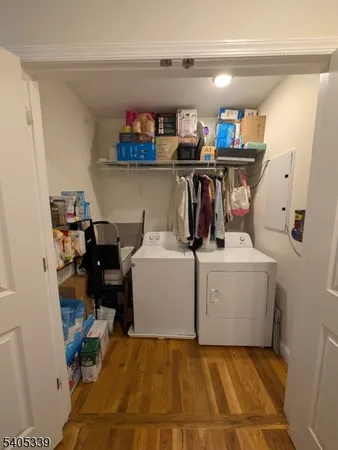 a utility room with dryer washer and a view of living room