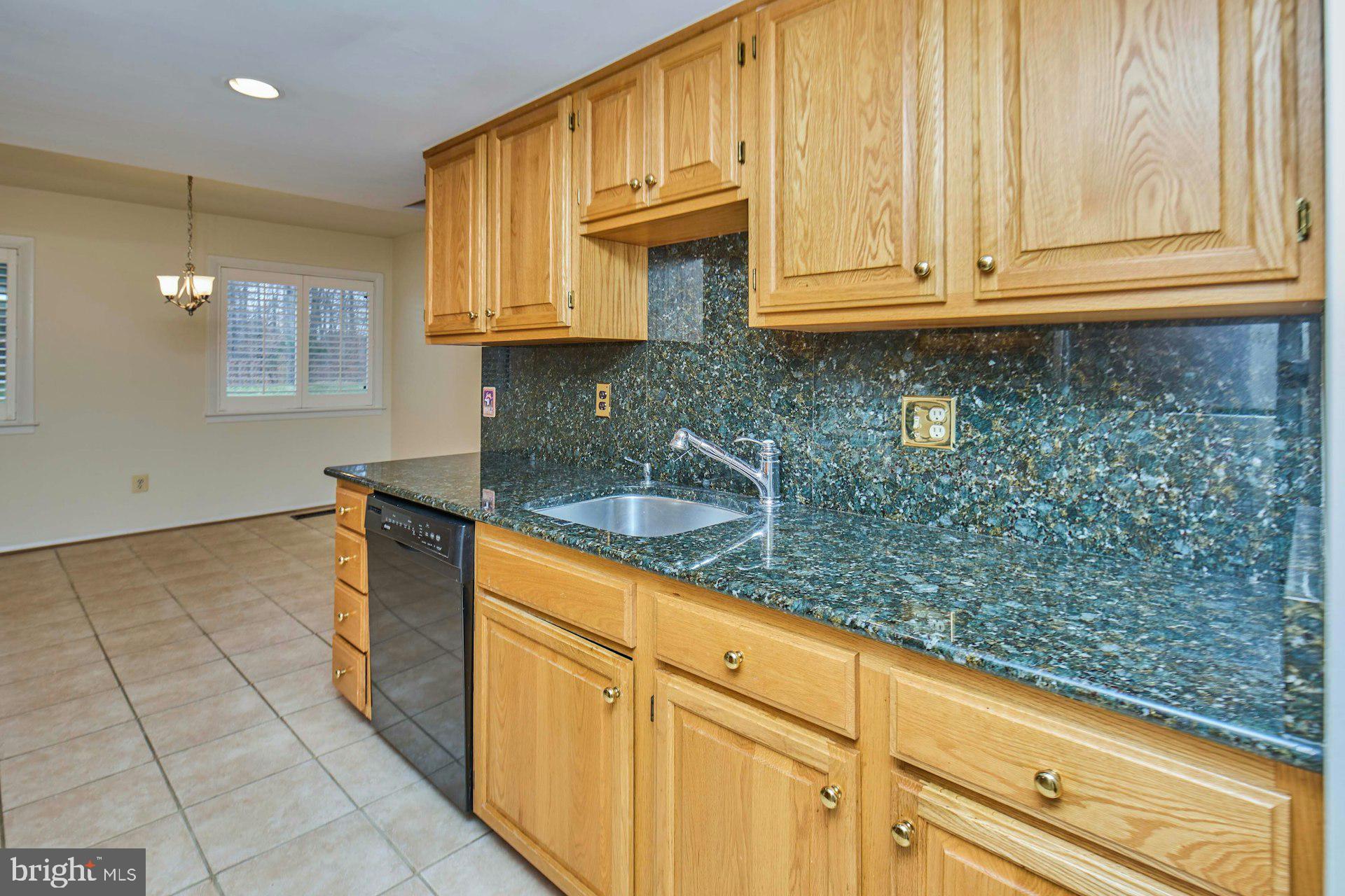 8566 Gwynedd Way Springfield, VA 22153 - Photo 10 of 61 a kitchen with granite countertop a sink and cabinets
