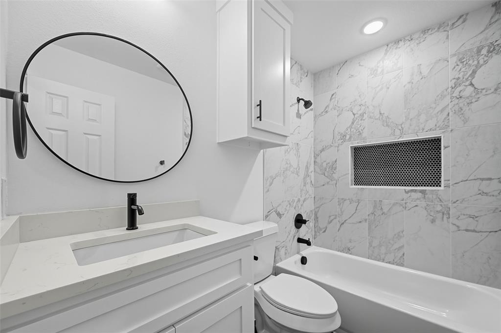 1315 Oneal Street, Unit A Commerce, TX 75428 - Photo 13 of 17 a bathroom with a sink a toilet and a mirror