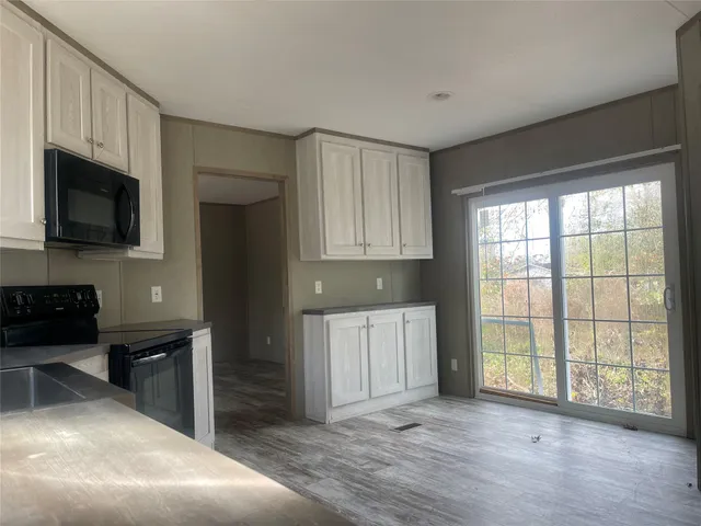 a view of an empty room with a fireplace and a window