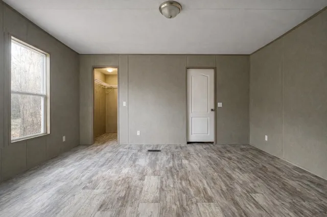 an empty room with windows and closet