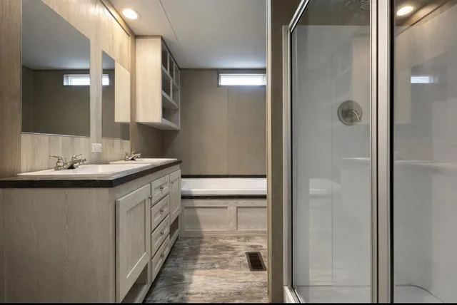 a bathroom with a double vanity sink mirror and shower
