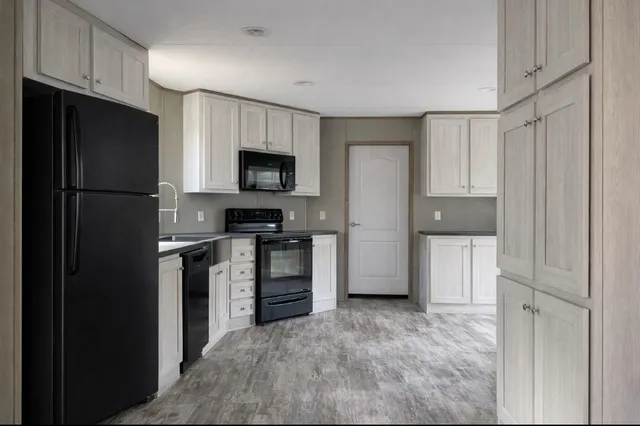 a kitchen with white cabinets and refrigerator