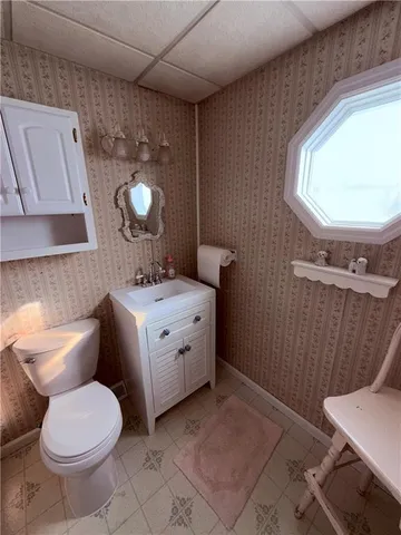 a bathroom with a toilet sink and mirror