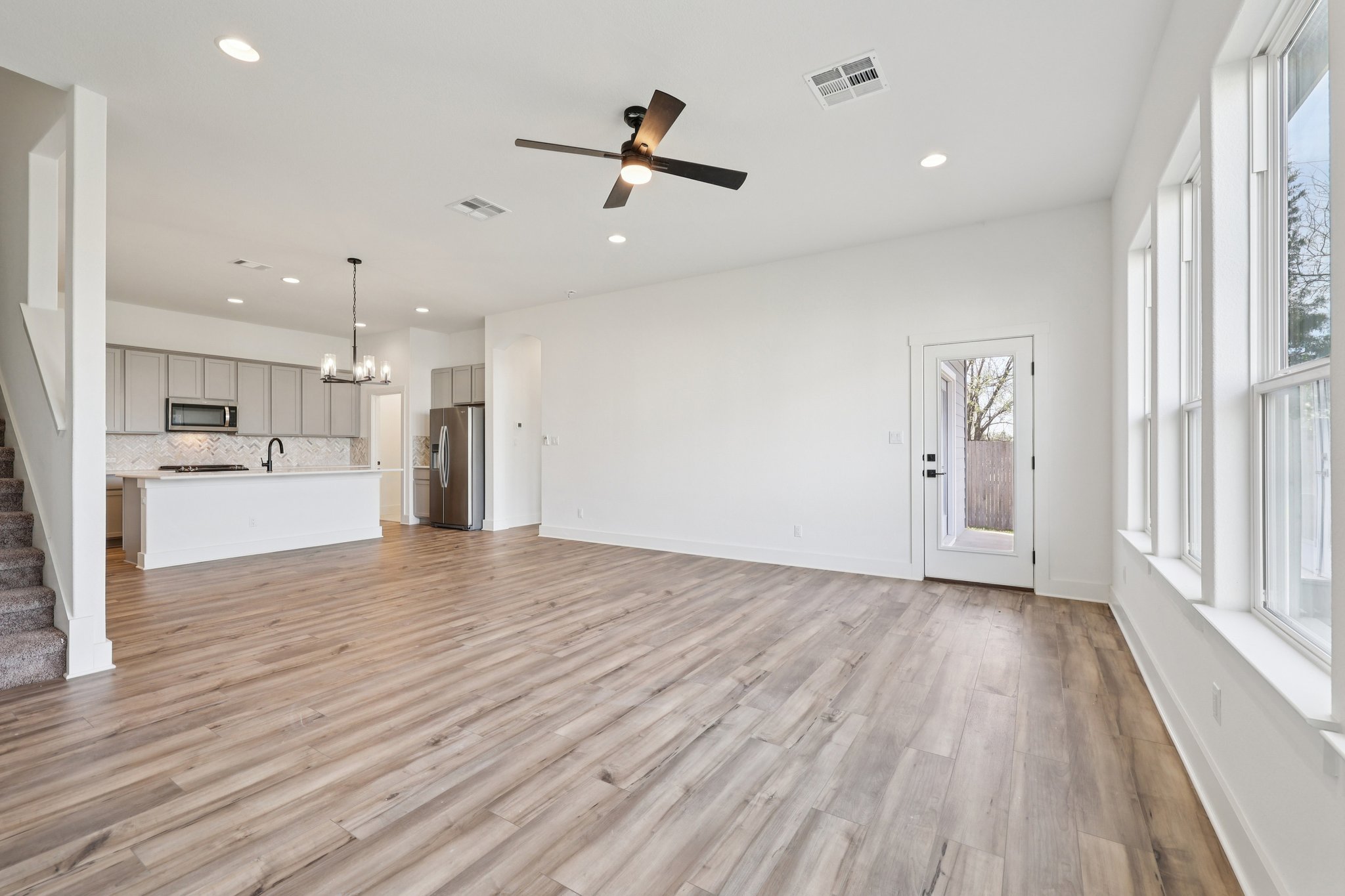 8760 Wellspring Loop Hutto, TX 78634 - Photo 10 of 37 Unfurnished living room with a chandelier, ceiling fan, and light wood-style floors