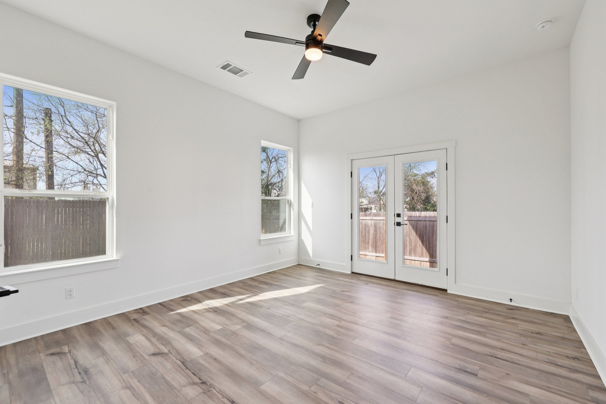 8760 Wellspring Loop Hutto, TX 78634 - Photo 19 of 37 Empty room featuring french doors, a ceiling fan, and light wood-style floors