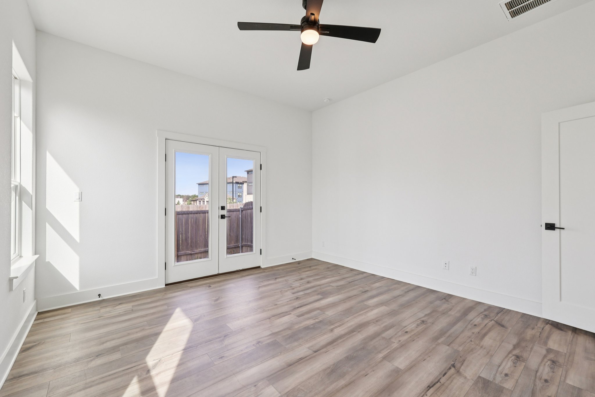 8760 Wellspring Loop Hutto, TX 78634 - Photo 22 of 37 Unfurnished room with french doors, ceiling fan, and light wood-style flooring