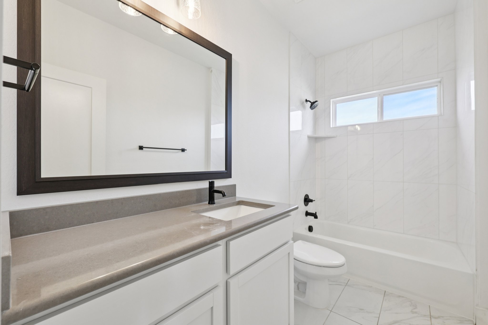 8760 Wellspring Loop Hutto, TX 78634 - Photo 28 of 37 Full bathroom featuring vanity, tub / shower combination, and light marble finish floors