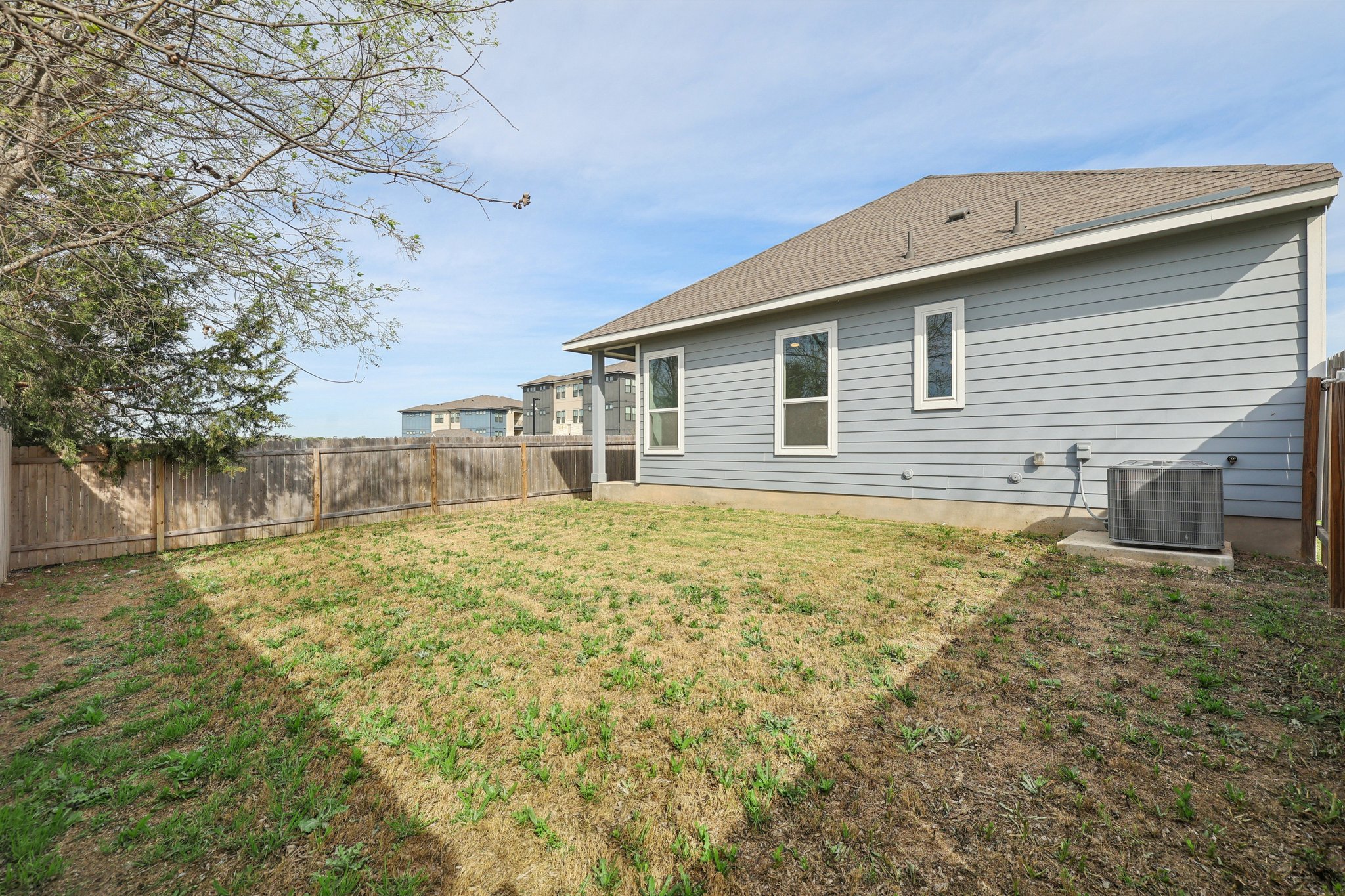 8760 Wellspring Loop Hutto, TX 78634 - Photo 4 of 37 Rear view of house featuring a fenced backyard and a shingled roof