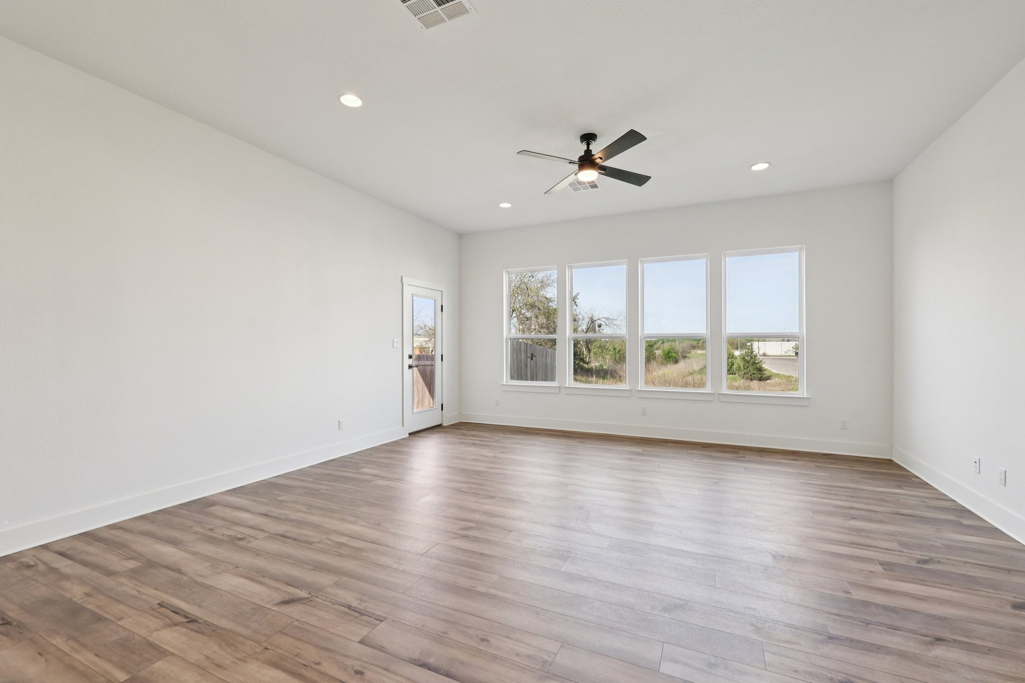 8760 Wellspring Loop Hutto, TX 78634 - Photo 8 of 37 Empty room featuring light wood finished floors, a ceiling fan, and recessed lighting