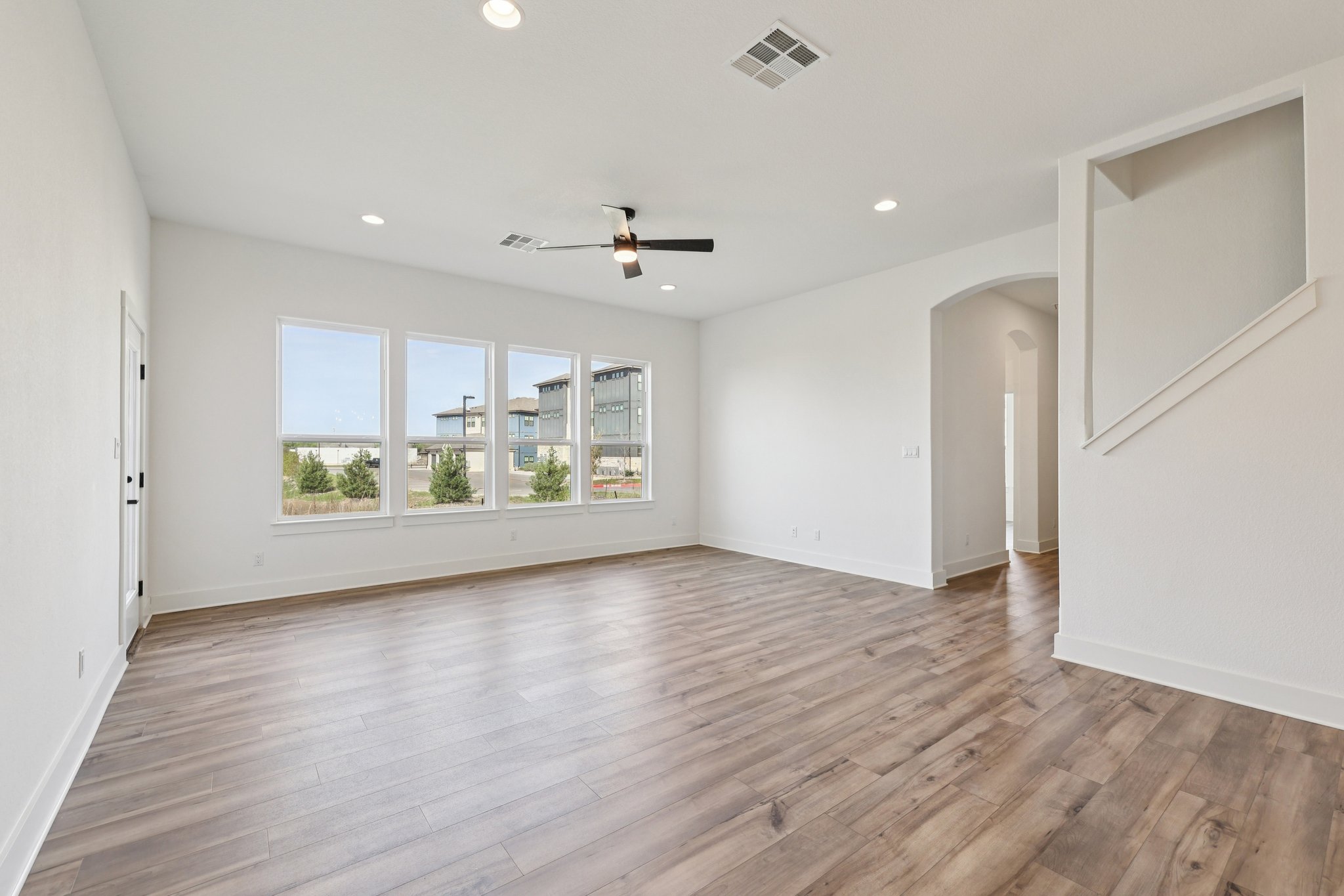 8760 Wellspring Loop Hutto, TX 78634 - Photo 9 of 37 Empty room with arched walkways, a ceiling fan, light wood-type flooring, and recessed lighting