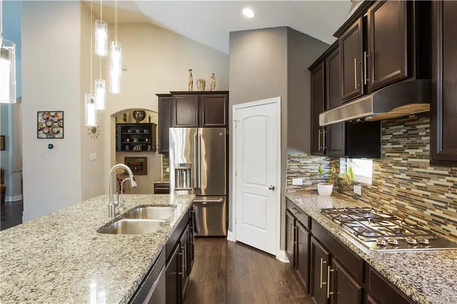 a kitchen with stainless steel appliances granite countertop a sink stove and refrigerator