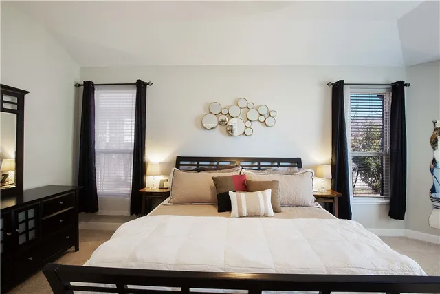 a bedroom with a large bed and a flat tv screen on dresser