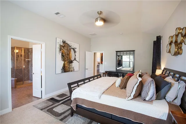 a bedroom with a bed a mirror and lamp