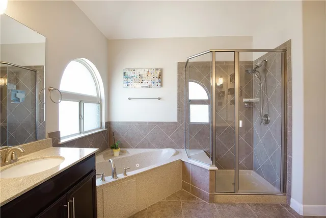 a bathroom with a tub sink and mirror
