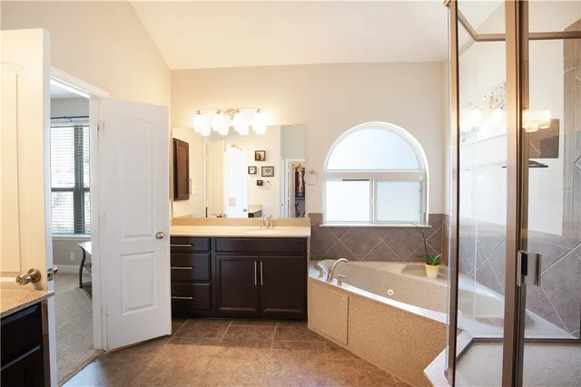 a bathroom with a tub sink and mirror