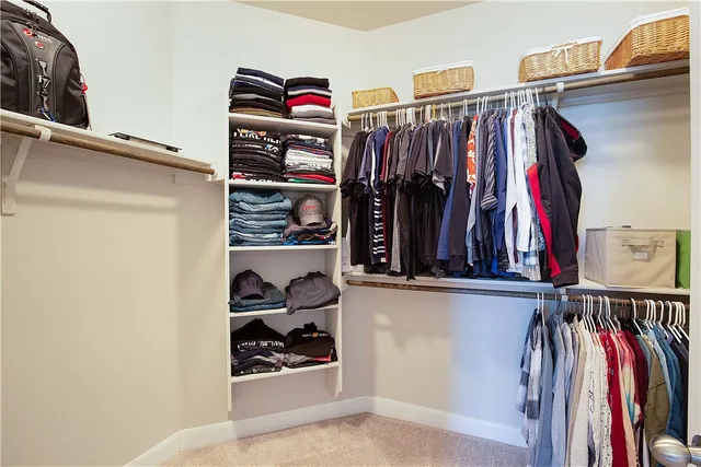 a view of walk in closet with clothes and shoes
