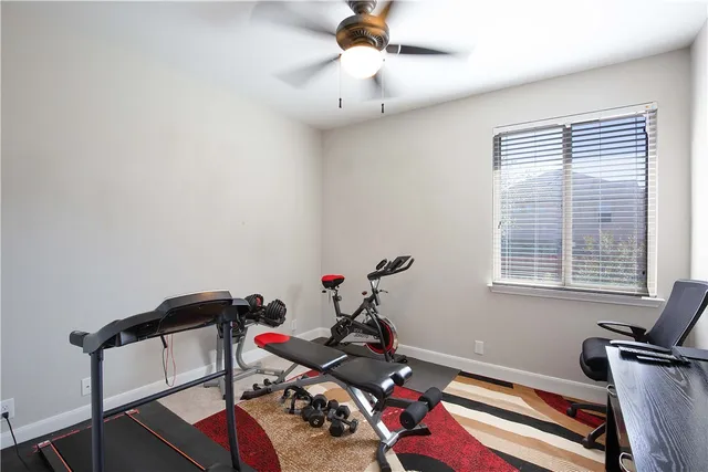 a room with gym equipment and wooden floor