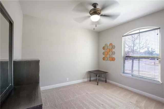 a view of an empty room with a window and a dresser