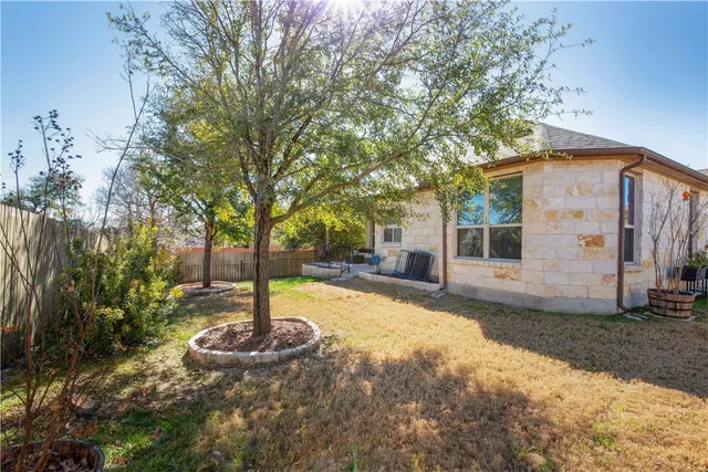 a view of a backyard with couches plants and wooden fence