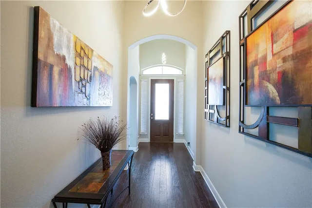 a view of a hallway with wooden floor and furniture